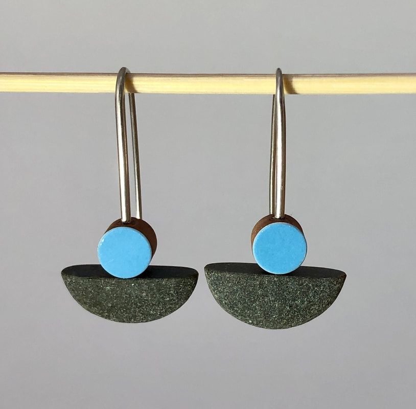 One pebble cut in half makes a matching pair of Earrings. A circle, cut from a blue tile has been placed on top of the pebbles. These ate mounted on Sterling Silver earwires