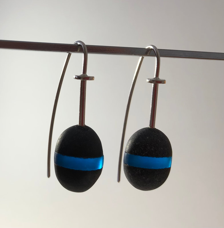 Earrings made from New Zealand Greywacke Pebbles with a Blue Glass line. They are suspended on a sterling silver wire and long earhooks.