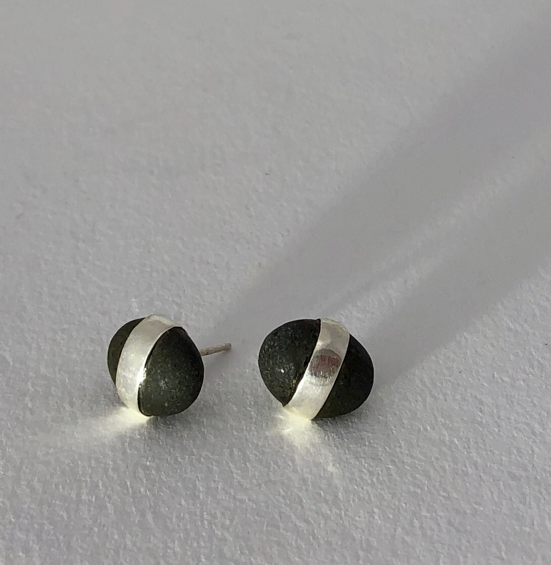 These stud earrings are made from small Greywacke pebbles. A pure silver band has been wrapped around them