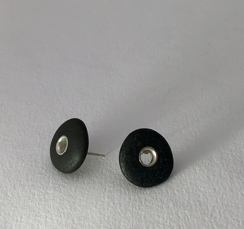 These Stud earrings are made from small black pebbles which have been drilled so a sterling Silver rivet could be inserted.