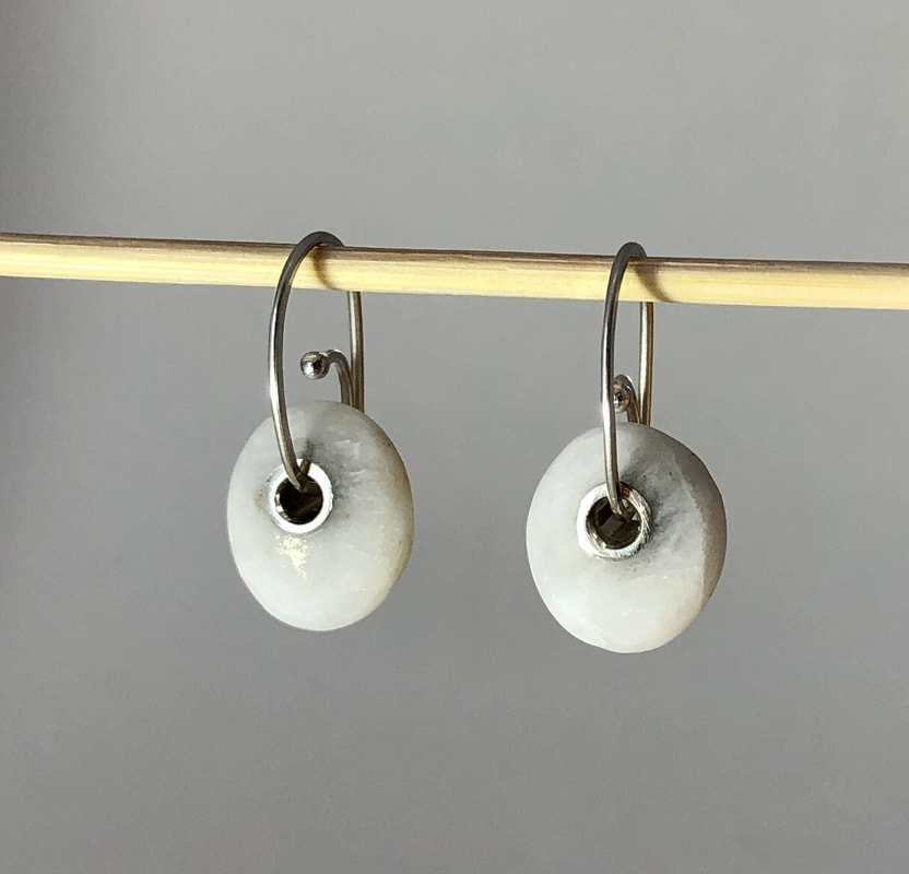 Picture of small pebble earrings made from white Quarz and Sterling Silver hook earwires. The smooth, oval pebbles is from the West Coast of New Zealand's South Island 